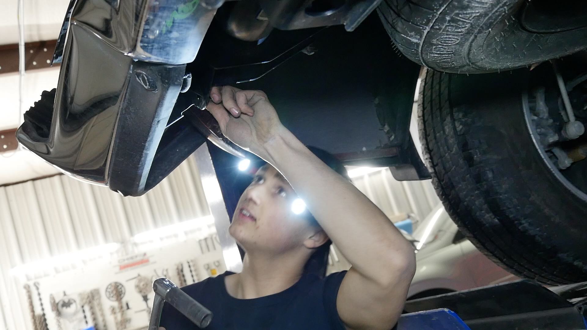 Mechanic inspecting the underside of a vehicle